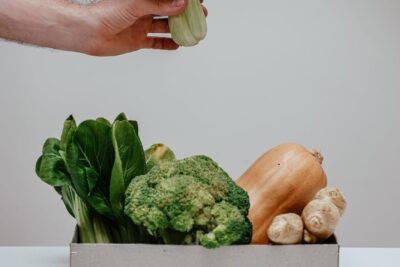 a person holding green bok choy vegetable